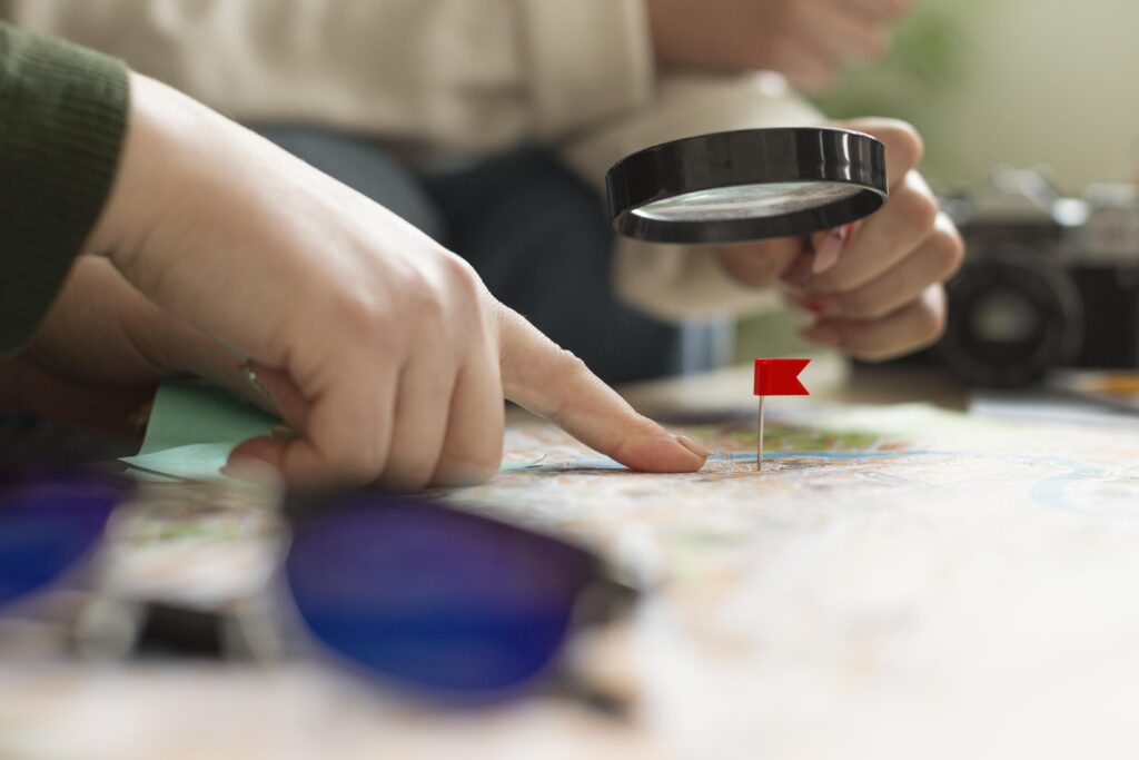 pessoas segurando uma lupa em cima de um mapa de terrenos