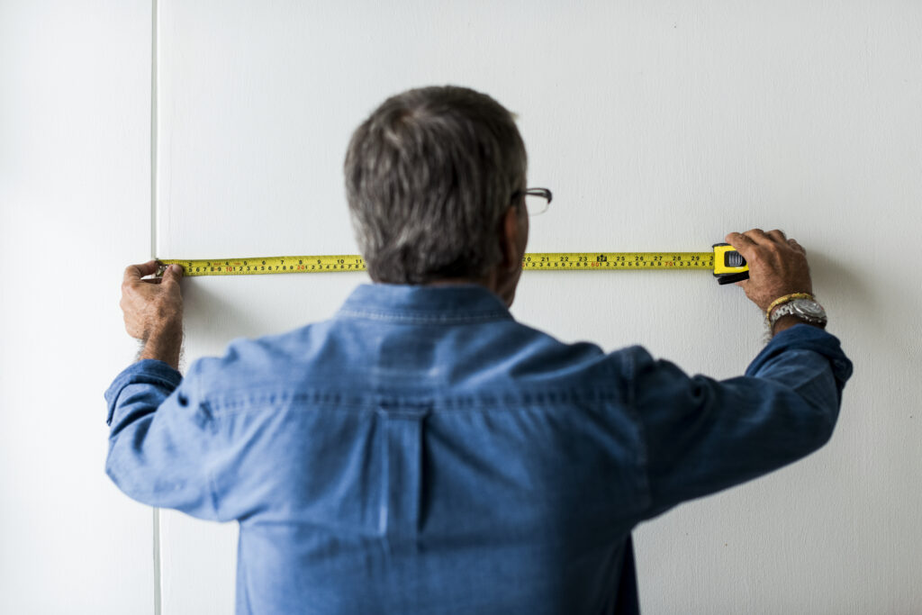 homem medindo porta com trena