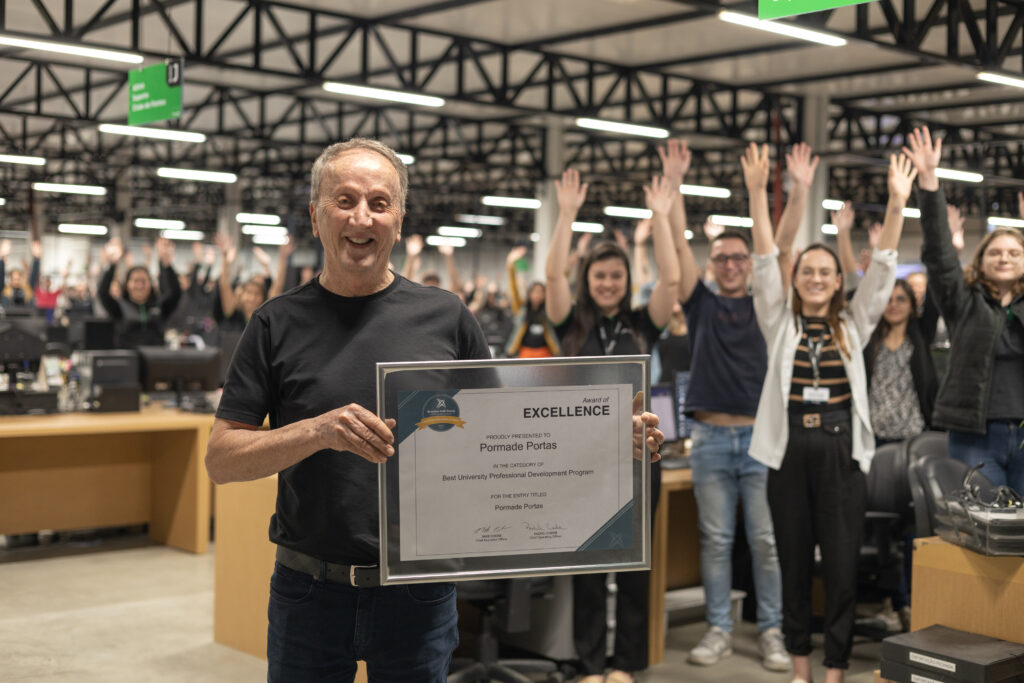 CEO Claudio Zini segurando certificado do prêmio com toda a equipe